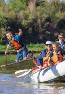 a kid jumping of a raft into the lower animas river