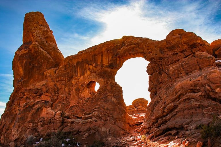 Sun shining through Arizona Arch for Insider tips about Arches National Park in Moab