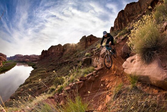 Mountain biker going down steep section of the Porcupine Rim Trail in Moab