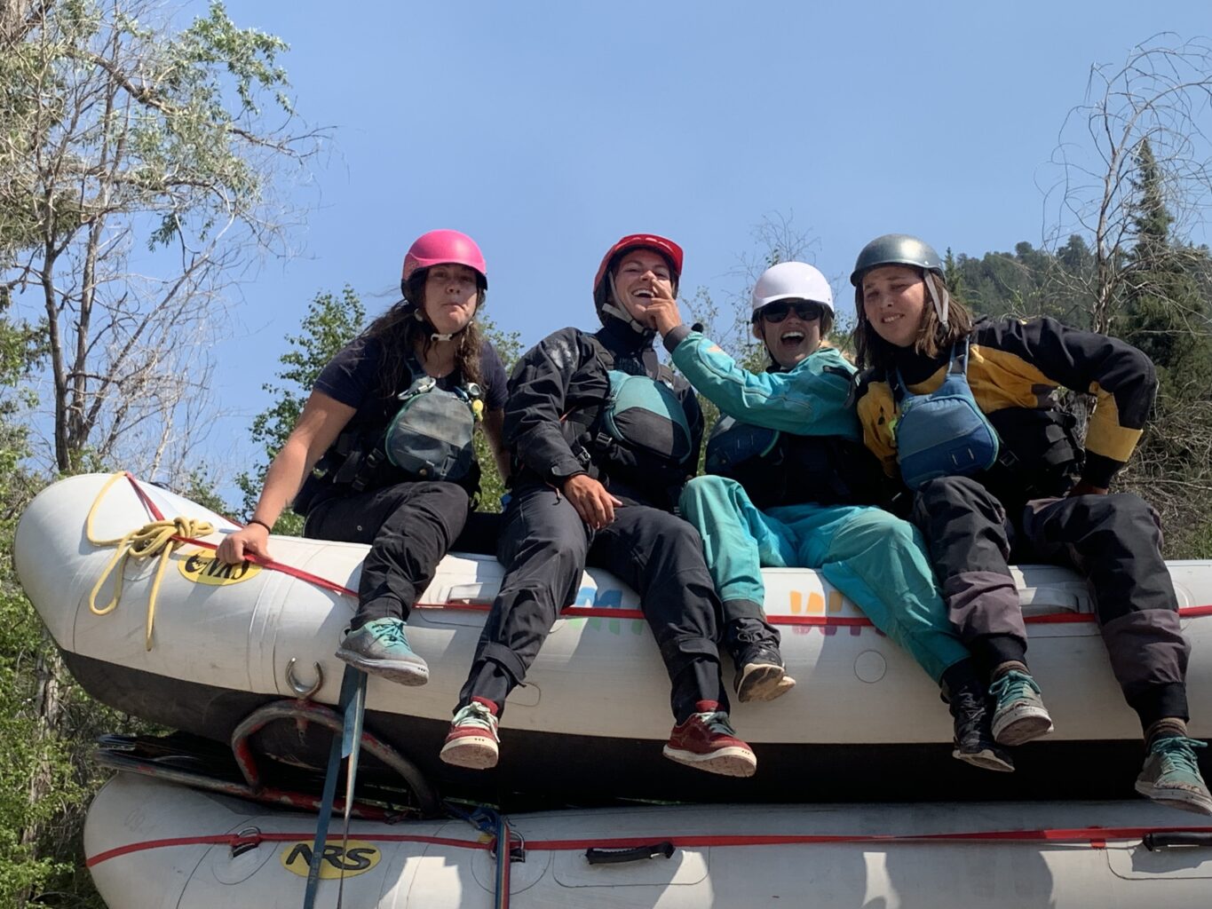 Four river guides sitting on a stack of rafts - San Miguel - Mild to Wild 