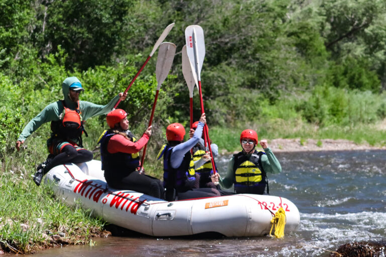 Rafters hold up their paddlers to each other in the boat on the San Miguel River - Mild to Wild