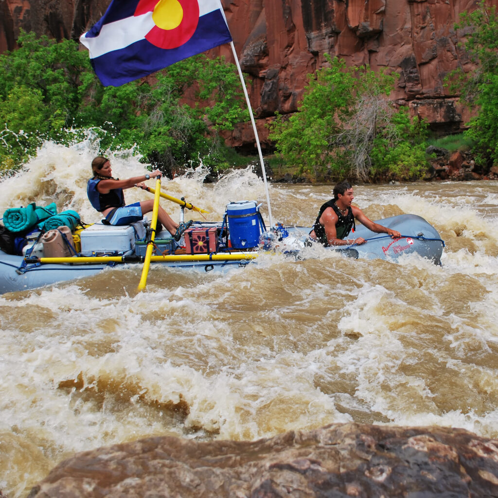 Yampa River - Close up of raft with Colorado flag going through white water rapids