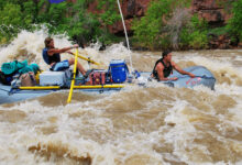 Yampa River - Close up of raft with Colorado flag going through white water rapids