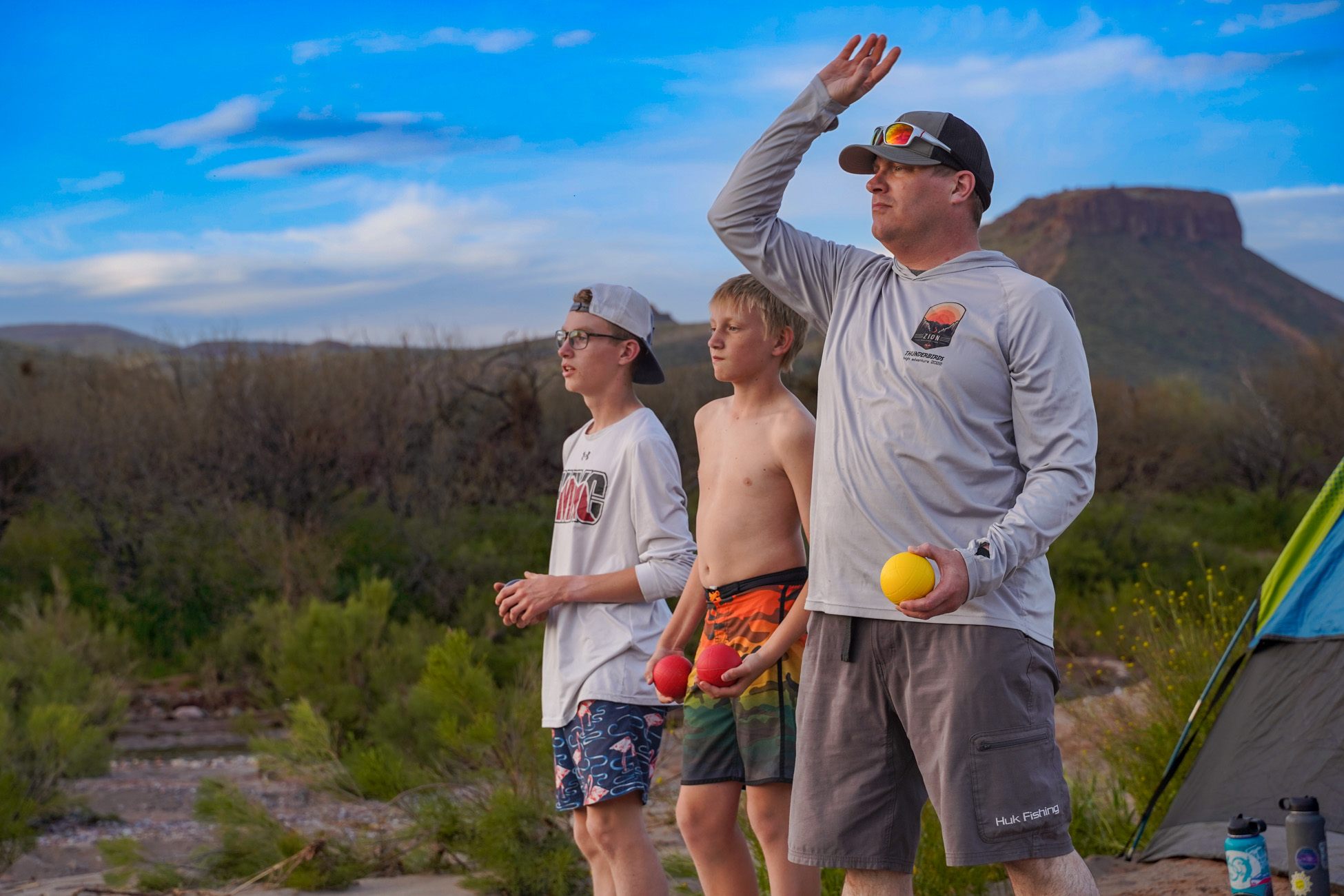 Upper Salt River Canyon Campsite - Close up of Family playing bocci-ball with mountains in the background