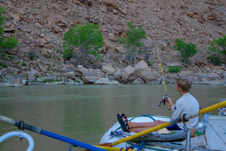 Boy fishing off a raft in Desolation Canyon - Mild to Wild