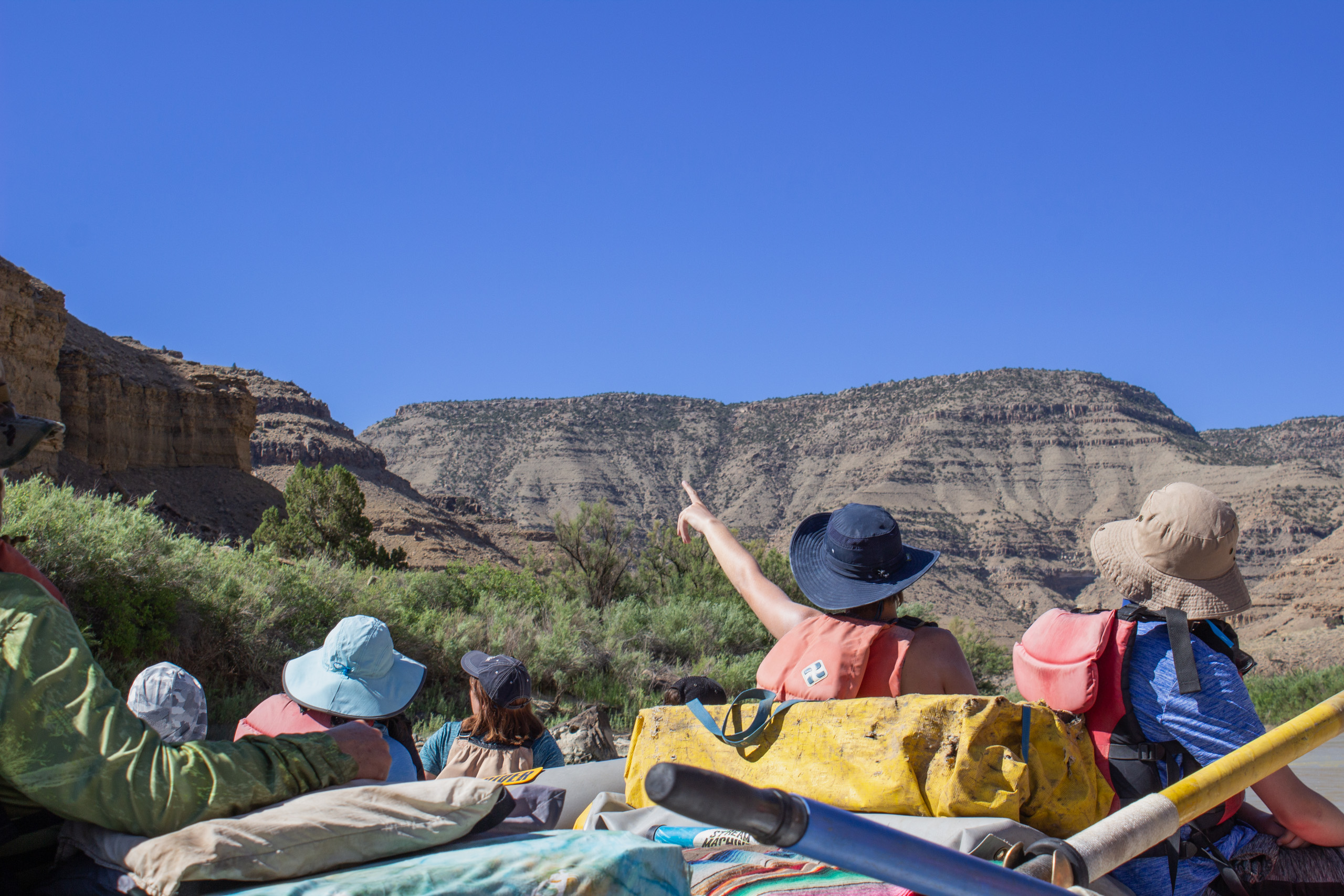 Desolation Canyon - Woman Pointing at Scenery on Boat - Mild to Wild