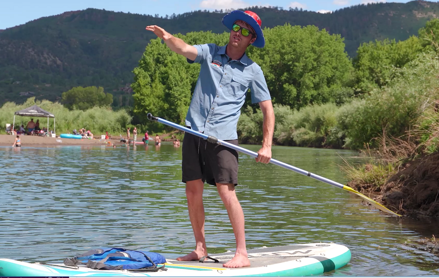 close up of guide on paddle board pointing about to give SUP tips - mild to wild