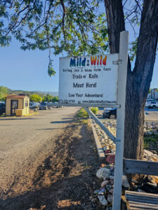 Medium shot of white wooden Mild to WIld sign on dirt road