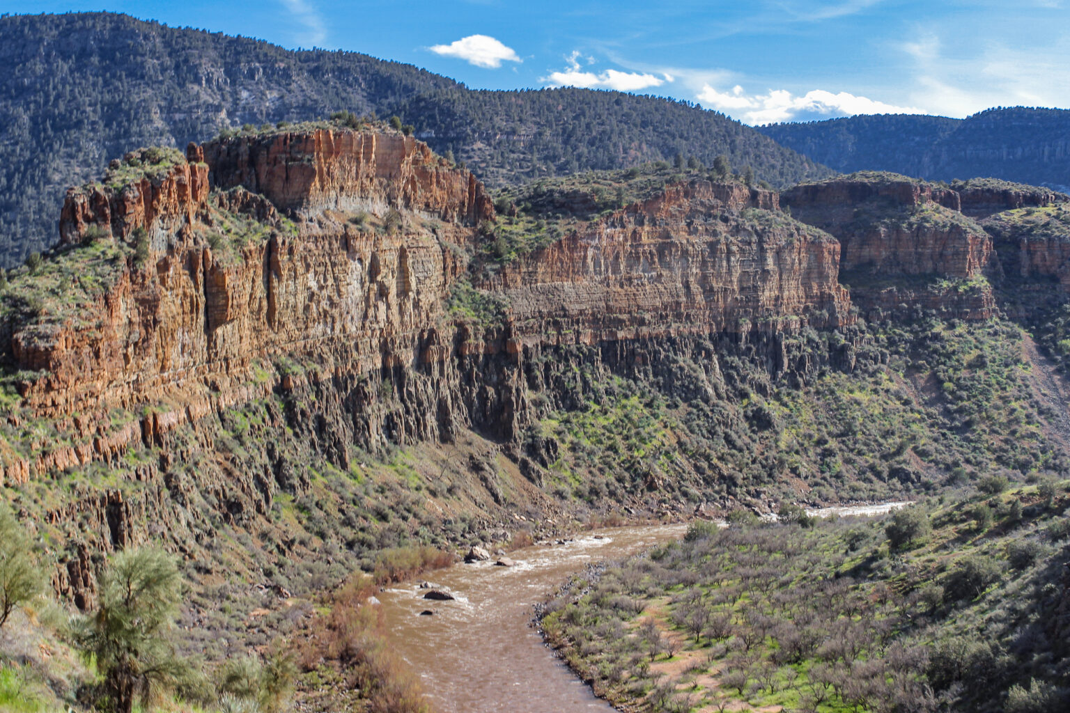 Grand view of a bend along the Upper Salt River Canyon with huge vertical cliffs looming above the river