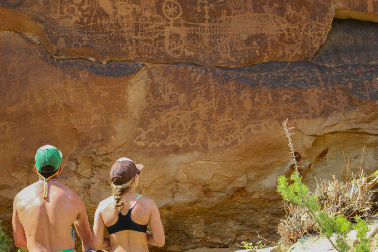 Couple admires the Fremont Petroglyph panel in Flat Canyon in Desolation Canyon