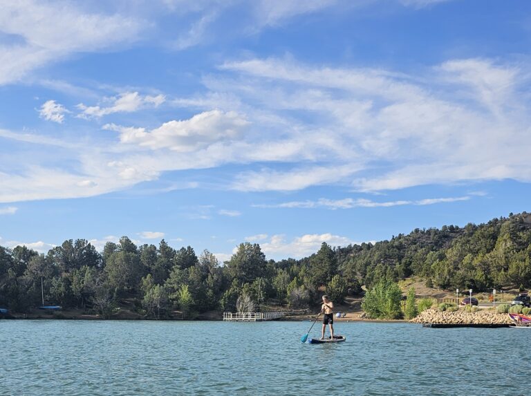 Man stand up paddling boarding on Lake Nighthorse near Durango, Colorado