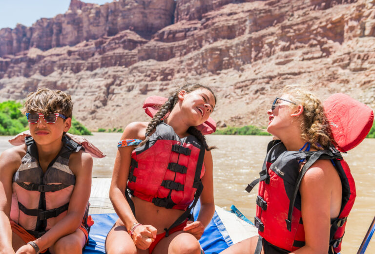 Kids smiling on a raft in Cataract Canyon