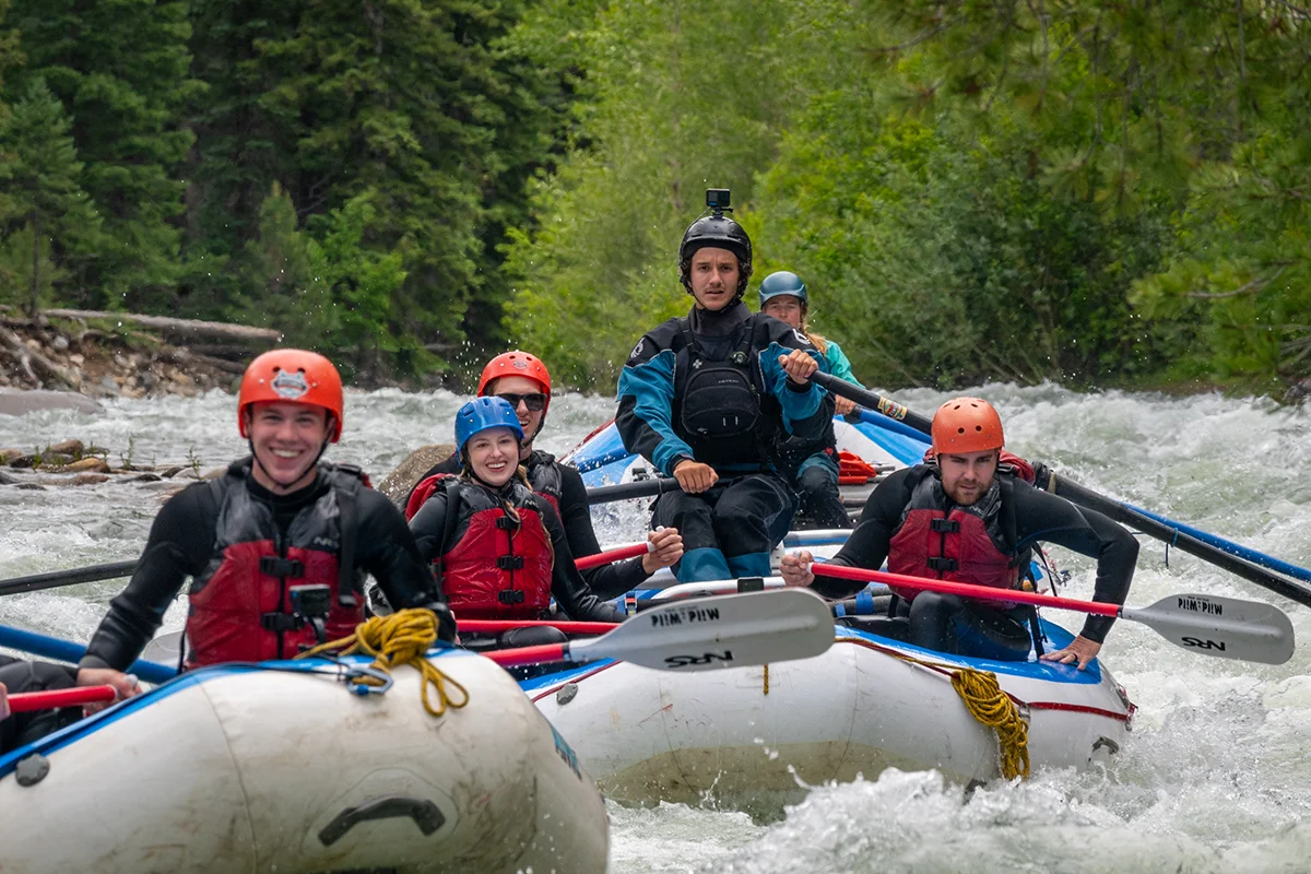 A rafting group with their guide, smiling as they float down the river